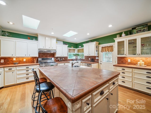 2442 Singleton Pt Unit 67, Liberty Hill, SC 29074 - kitchen with a skylight, decorative backsplash, gas range, light wood finished floors, and a kitchen bar