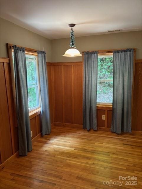 2070 Cashiers Valley Rd, Brevard, NC 28712 - unfurnished dining area with healthy amount of natural light, light wood-style floors, wood walls, and wainscoting