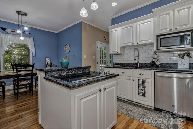 2790 Twin Oaks Dr, Morganton, NC 28655 - kitchen with appliances with stainless steel finishes, light wood-style flooring, a center island, backsplash, and white cabinets