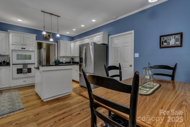 2790 Twin Oaks Dr, Morganton, NC 28655 - kitchen with stainless steel fridge with ice dispenser, double oven, a center island, dark countertops, and white cabinets