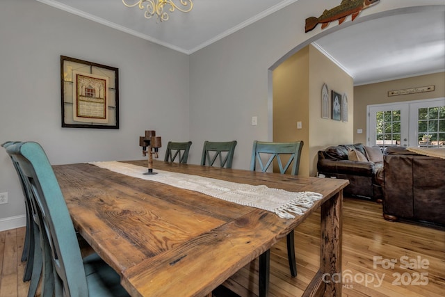 2790 Twin Oaks Dr, Morganton, NC 28655 - dining area featuring ornamental molding, light wood-type flooring, arched walkways, french doors, and a chandelier