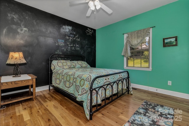 2790 Twin Oaks Dr, Morganton, NC 28655 - bedroom featuring wood-type flooring, an accent wall, and ceiling fan