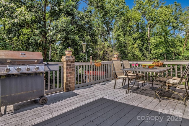 2790 Twin Oaks Dr, Morganton, NC 28655 - wooden terrace featuring outdoor dining area, a grill, and view of wooded area
