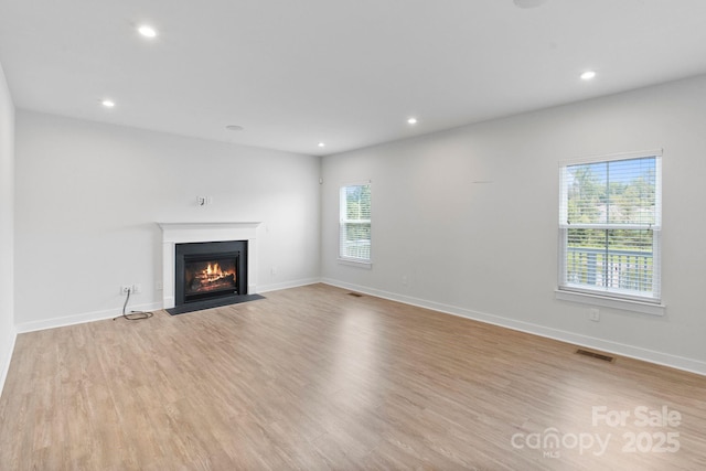 207 Welcombe St, Mooresville, NC 28115 - unfurnished living room with a fireplace with flush hearth, light wood-type flooring, recessed lighting, and baseboards