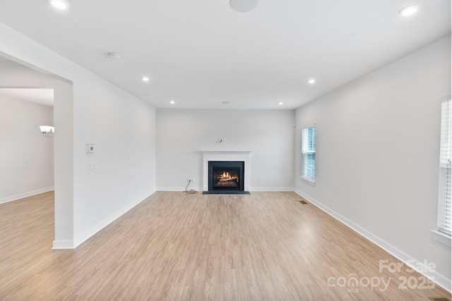 207 Welcombe St, Mooresville, NC 28115 - unfurnished living room with light wood-type flooring, a fireplace with flush hearth, recessed lighting, and baseboards