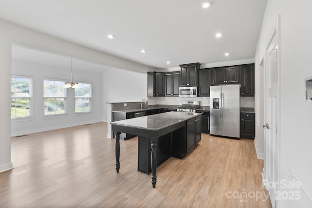 207 Welcombe St, Mooresville, NC 28115 - kitchen with appliances with stainless steel finishes, dark cabinetry, a chandelier, light wood finished floors, and recessed lighting