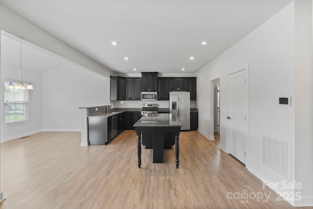 207 Welcombe St, Mooresville, NC 28115 - kitchen with appliances with stainless steel finishes, a sink, dark cabinets, a chandelier, and a breakfast bar area