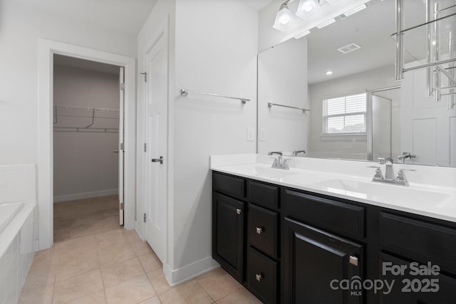 207 Welcombe St, Mooresville, NC 28115 - full bathroom featuring double vanity, a bath, tile patterned flooring, an enclosed shower, and a walk in closet