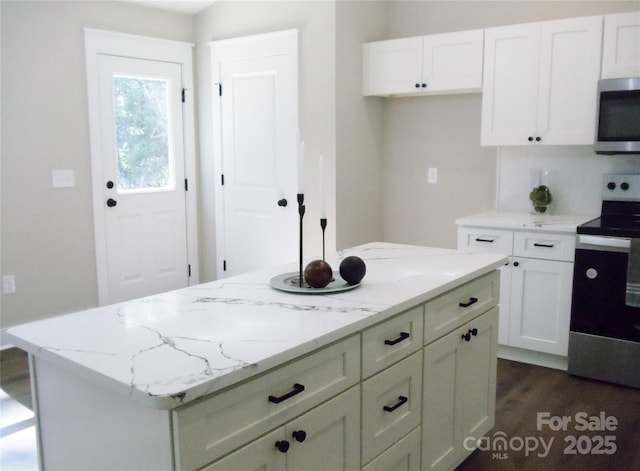 1802 Cooper Ave, Kannapolis, NC 28081 - kitchen featuring stainless steel appliances, white cabinets, light stone countertops, a center island, and dark wood-type flooring