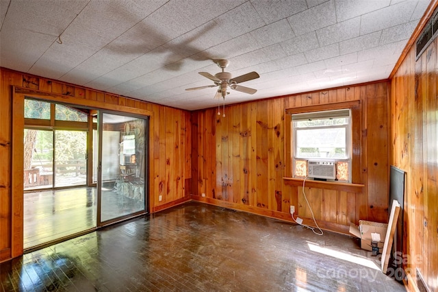 3960 Old Clyde Rd, Clyde, NC 28721 - unfurnished room featuring hardwood / wood-style flooring, wooden walls, a ceiling fan, and baseboards