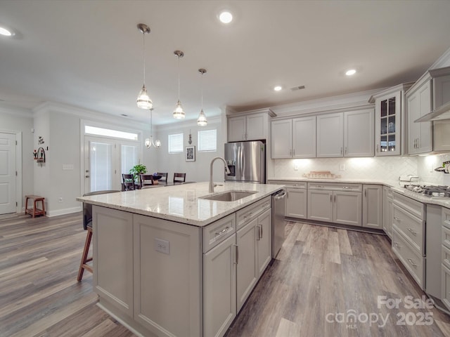 647 R L Stowe Rd, Belmont, NC 28012 - kitchen with stainless steel appliances, a sink, a kitchen breakfast bar, ornamental molding, and wood finished floors