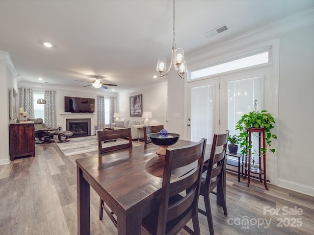 647 R L Stowe Rd, Belmont, NC 28012 - dining area with crown molding, light wood finished floors, a ceiling fan, baseboards, and a fireplace