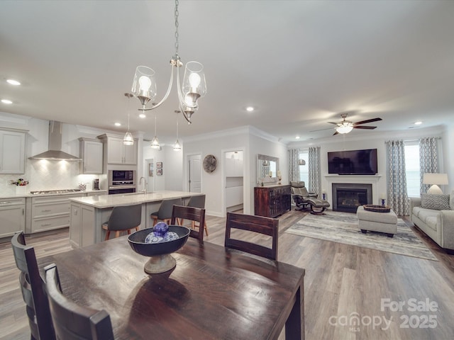 647 R L Stowe Rd, Belmont, NC 28012 - dining room featuring recessed lighting, ceiling fan, wood finished floors, crown molding, and a glass covered fireplace