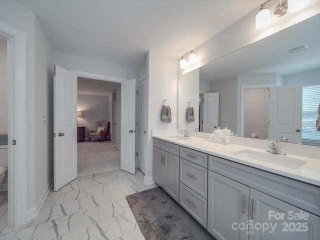 647 R L Stowe Rd, Belmont, NC 28012 - ensuite bathroom featuring marble look tiles, toilet, double vanity, and baseboards