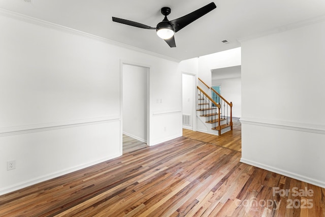 9513 Saddle Run Trl, Charlotte, NC 28269 - spare room featuring stairway, light wood-style floors, a ceiling fan, crown molding, and baseboards
