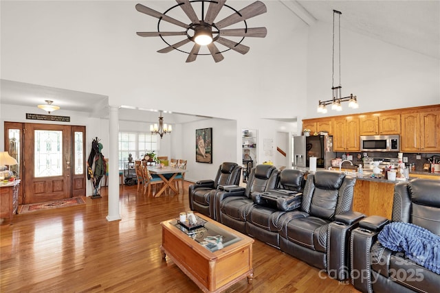 1530 Danlee Dr, Lancaster, SC 29720 - living area featuring a chandelier, decorative columns, light wood finished floors, a ceiling fan, and high vaulted ceiling