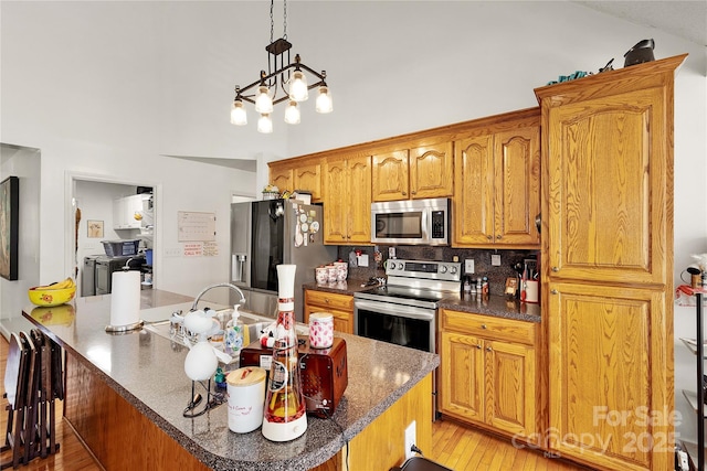 1530 Danlee Dr, Lancaster, SC 29720 - kitchen featuring appliances with stainless steel finishes, tasteful backsplash, light wood-style flooring, and brown cabinets
