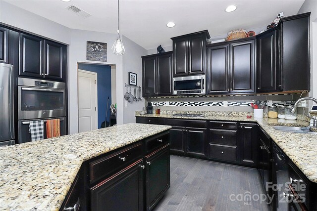 7434 Dover Mill Ln SW, Concord, NC 28025 - kitchen with a sink, appliances with stainless steel finishes, dark cabinetry, dark wood-type flooring, and light stone countertops