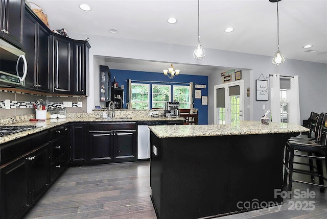 7434 Dover Mill Ln SW, Concord, NC 28025 - kitchen with a sink, appliances with stainless steel finishes, dark cabinets, dark wood finished floors, and a chandelier