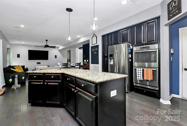 7434 Dover Mill Ln SW, Concord, NC 28025 - kitchen featuring stainless steel appliances, dark cabinets, dark wood-style floors, open floor plan, and a ceiling fan