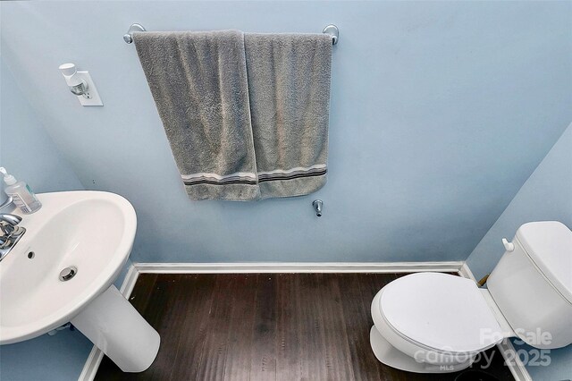 7434 Dover Mill Ln SW, Concord, NC 28025 - half bathroom with wood finished floors, baseboards, a sink, and toilet