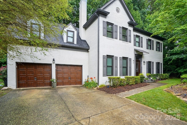 8708 Piccone Brook Ln, Charlotte, NC 28216 - view of front facade featuring brick siding, a chimney, concrete driveway, and a garage