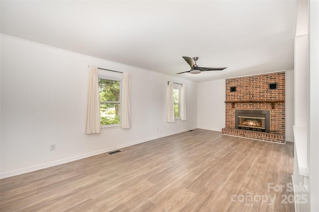 3595 Mt Holly Rd, Edgemoor, SC 29712 - unfurnished living room with light wood-style floors, plenty of natural light, ceiling fan, and a fireplace