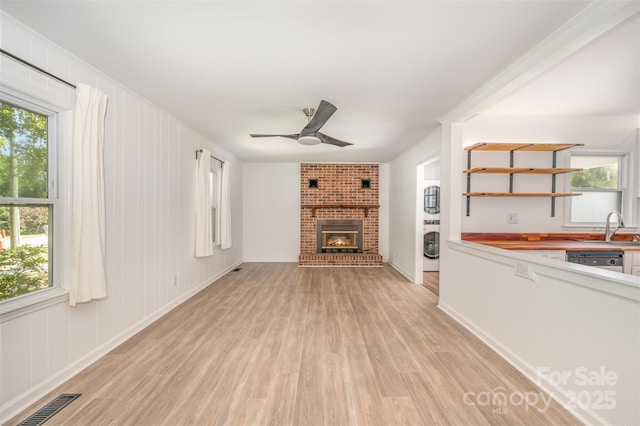 3595 Mt Holly Rd, Edgemoor, SC 29712 - unfurnished living room featuring light wood-type flooring, ceiling fan, a sink, and healthy amount of natural light
