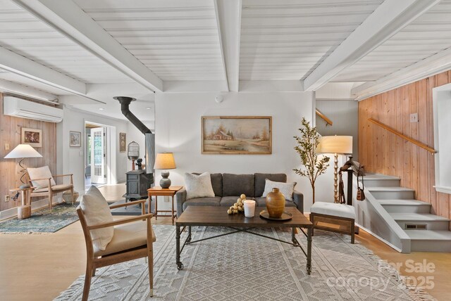 20 Pickens Ln, Weaverville, NC 28787 - living room featuring a wall unit AC, wooden walls, a wood stove, wood finished floors, and beam ceiling