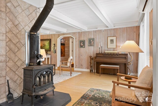 20 Pickens Ln, Weaverville, NC 28787 - living room featuring a wood stove, beamed ceiling, wood finished floors, arched walkways, and wooden walls