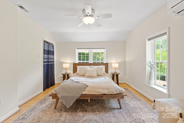 20 Pickens Ln, Weaverville, NC 28787 - bedroom with a wall unit AC, multiple windows, light wood-style flooring, and lofted ceiling