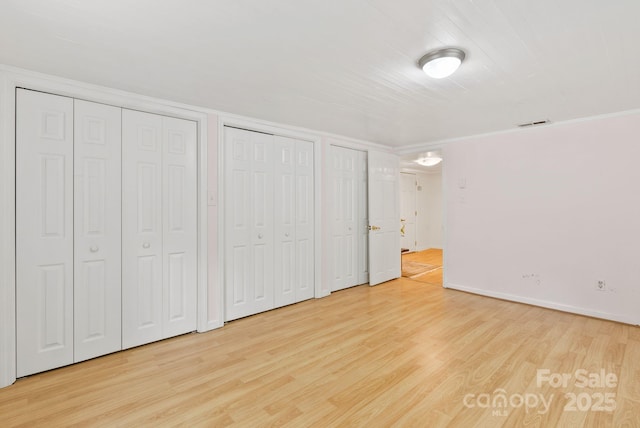 20 Pickens Ln, Weaverville, NC 28787 - unfurnished bedroom featuring two closets, light wood-type flooring, baseboards, and crown molding