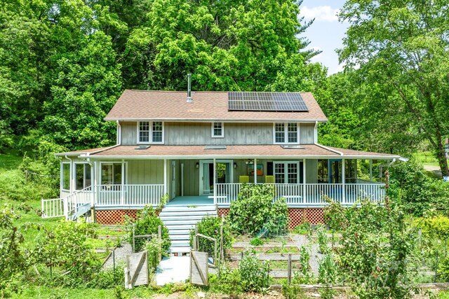 20 Pickens Ln, Weaverville, NC 28787 - view of front of home featuring a porch, solar panels, board and batten siding, a view of trees, and roof with shingles