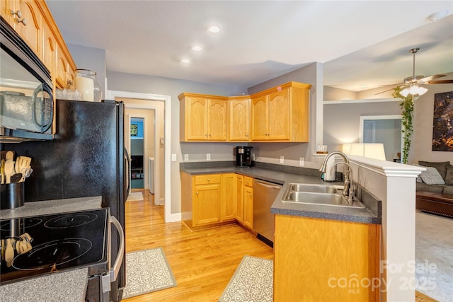 1209 Danielle Downs Ct SE, Concord, NC 28025 - kitchen featuring black appliances, a sink, dark countertops, light wood-type flooring, and a peninsula