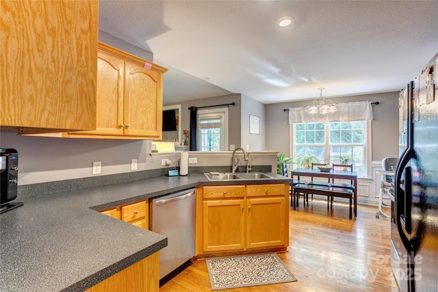 1209 Danielle Downs Ct SE, Concord, NC 28025 - kitchen featuring stainless steel dishwasher, a sink, a peninsula, dark countertops, and light wood-type flooring