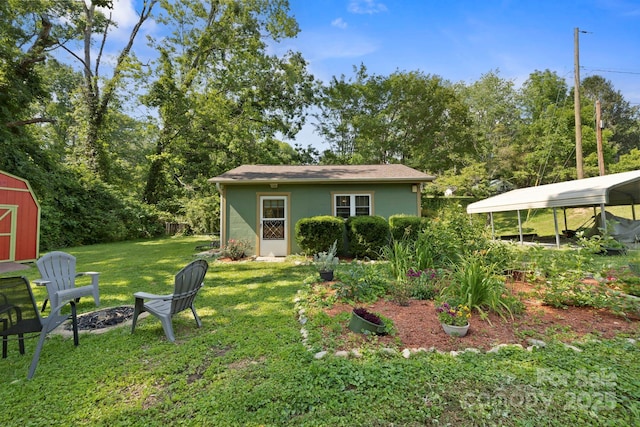 32 Roberts St, Fletcher, NC 28732 - back of house featuring a yard, a fire pit, and a carport