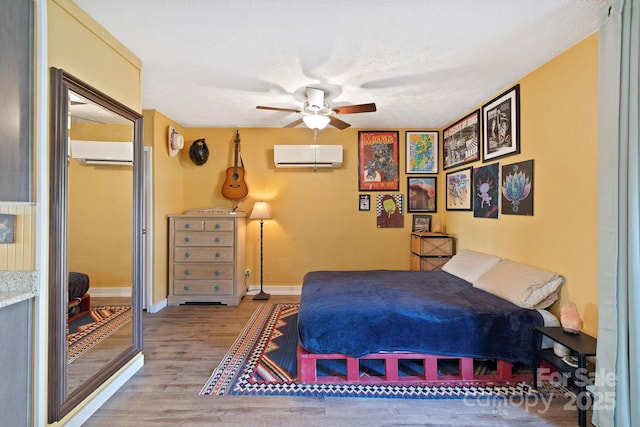 32 Roberts St, Fletcher, NC 28732 - bedroom featuring an AC wall unit, wood finished floors, baseboards, and ceiling fan