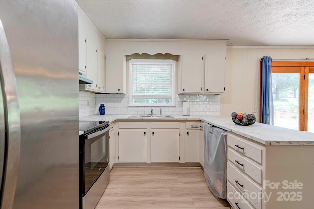 3043 Charles Rd, Shelby, NC 28152 - kitchen with stainless steel appliances, a sink, a peninsula, a textured ceiling, and light wood-style floors