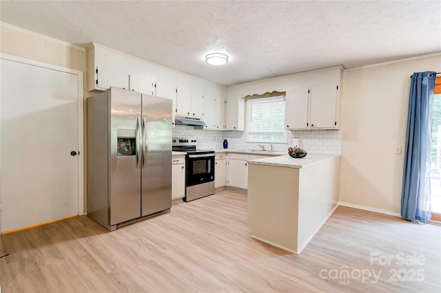 3043 Charles Rd, Shelby, NC 28152 - kitchen featuring appliances with stainless steel finishes, under cabinet range hood, light wood-style floors, a peninsula, and light countertops
