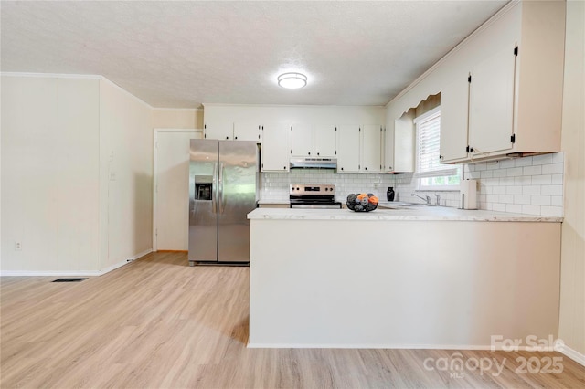 3043 Charles Rd, Shelby, NC 28152 - kitchen with appliances with stainless steel finishes, under cabinet range hood, light wood-style floors, backsplash, and a textured ceiling