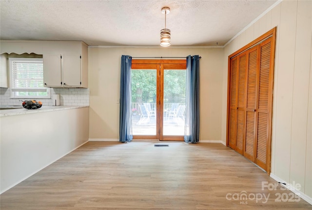 3043 Charles Rd, Shelby, NC 28152 - unfurnished dining area with light wood-style flooring, a textured ceiling, healthy amount of natural light, ornamental molding, and baseboards