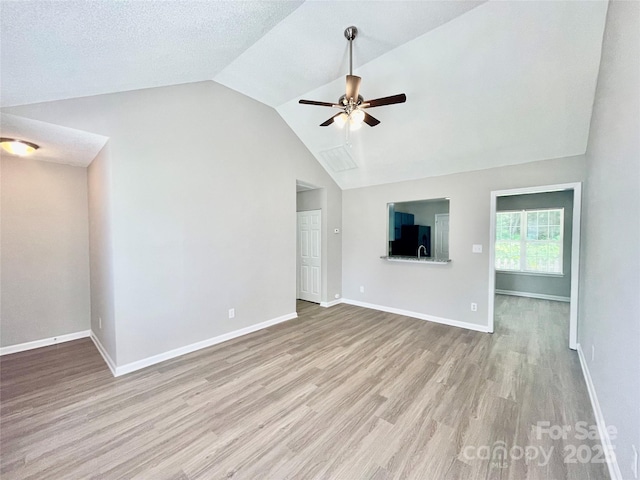 5800 Silver Eagle Dr, Charlotte, NC 28214 - unfurnished living room featuring a ceiling fan, light wood-type flooring, baseboards, and high vaulted ceiling