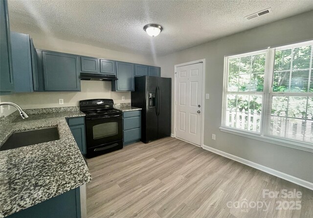 5800 Silver Eagle Dr, Charlotte, NC 28214 - kitchen featuring black appliances, a sink, under cabinet range hood, a textured ceiling, and dark stone counters