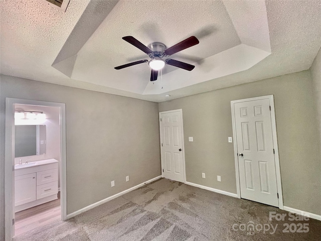 5800 Silver Eagle Dr, Charlotte, NC 28214 - unfurnished bedroom with a raised ceiling, a textured ceiling, baseboards, a sink, and light carpet