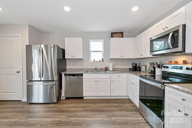 3305 Rian Dr, Lenoir, NC 28645 - kitchen with stainless steel appliances, a sink, recessed lighting, white cabinets, and wood finished floors