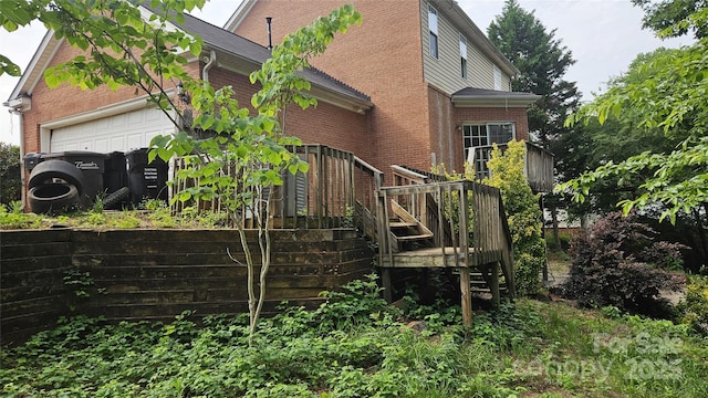 4227 Kiser Woods Dr SW, Concord, NC 28025 - rear view of property featuring brick siding, an attached garage, stairway, and a deck