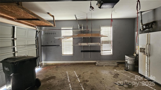 4227 Kiser Woods Dr SW, Concord, NC 28025 - garage featuring white fridge with ice dispenser, a garage door opener, and baseboards