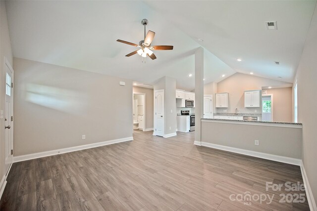 1028 Gibson St, Albemarle, NC 28001 - unfurnished living room with ceiling fan, light wood-type flooring, baseboards, high vaulted ceiling, and recessed lighting