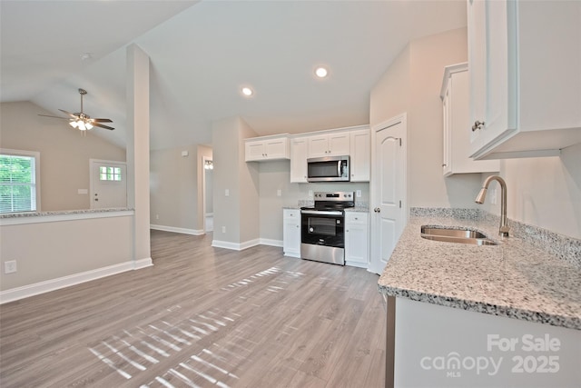 1028 Gibson St, Albemarle, NC 28001 - kitchen with appliances with stainless steel finishes, a sink, white cabinetry, light stone counters, and light wood finished floors