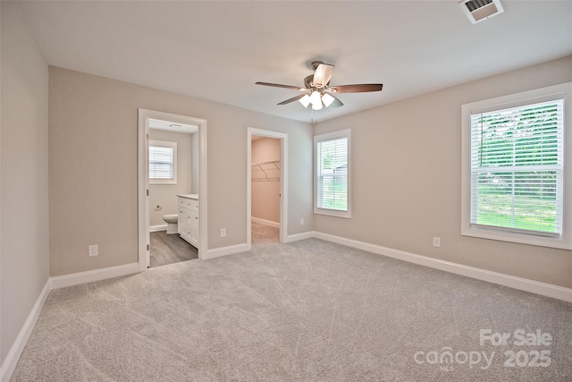 1028 Gibson St, Albemarle, NC 28001 - unfurnished bedroom with a spacious closet, carpet flooring, baseboards, connected bathroom, and a closet